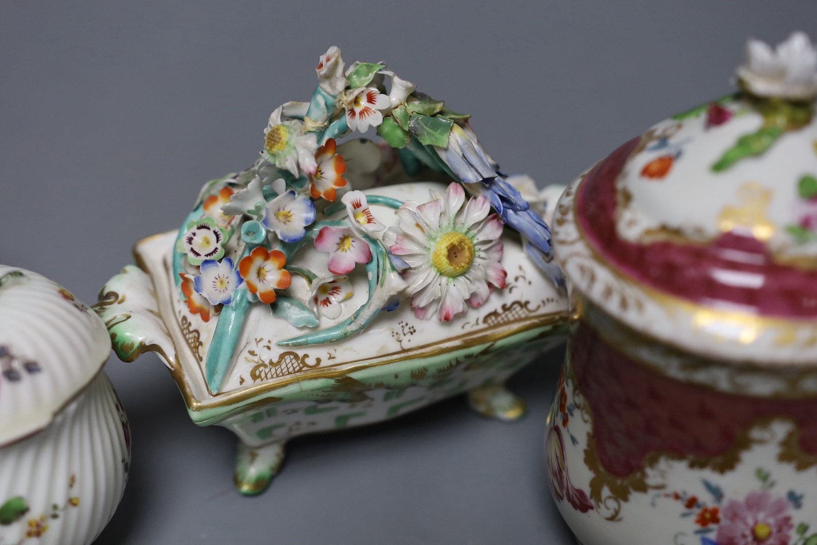 An 18th century Mennecy porcelain cup and cover, a Meissen style cup and cover, an English porcelain floral encrusted double inkwell and cover and a similar jar and cover